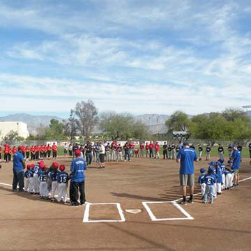 Little League teams standing on baselines