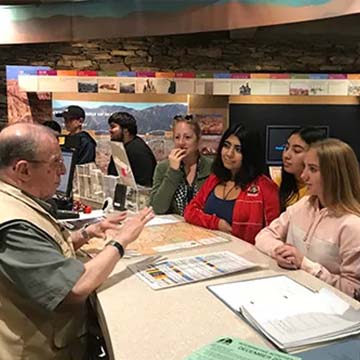 Volunteer talking to park visitors at Visitor's Center counter